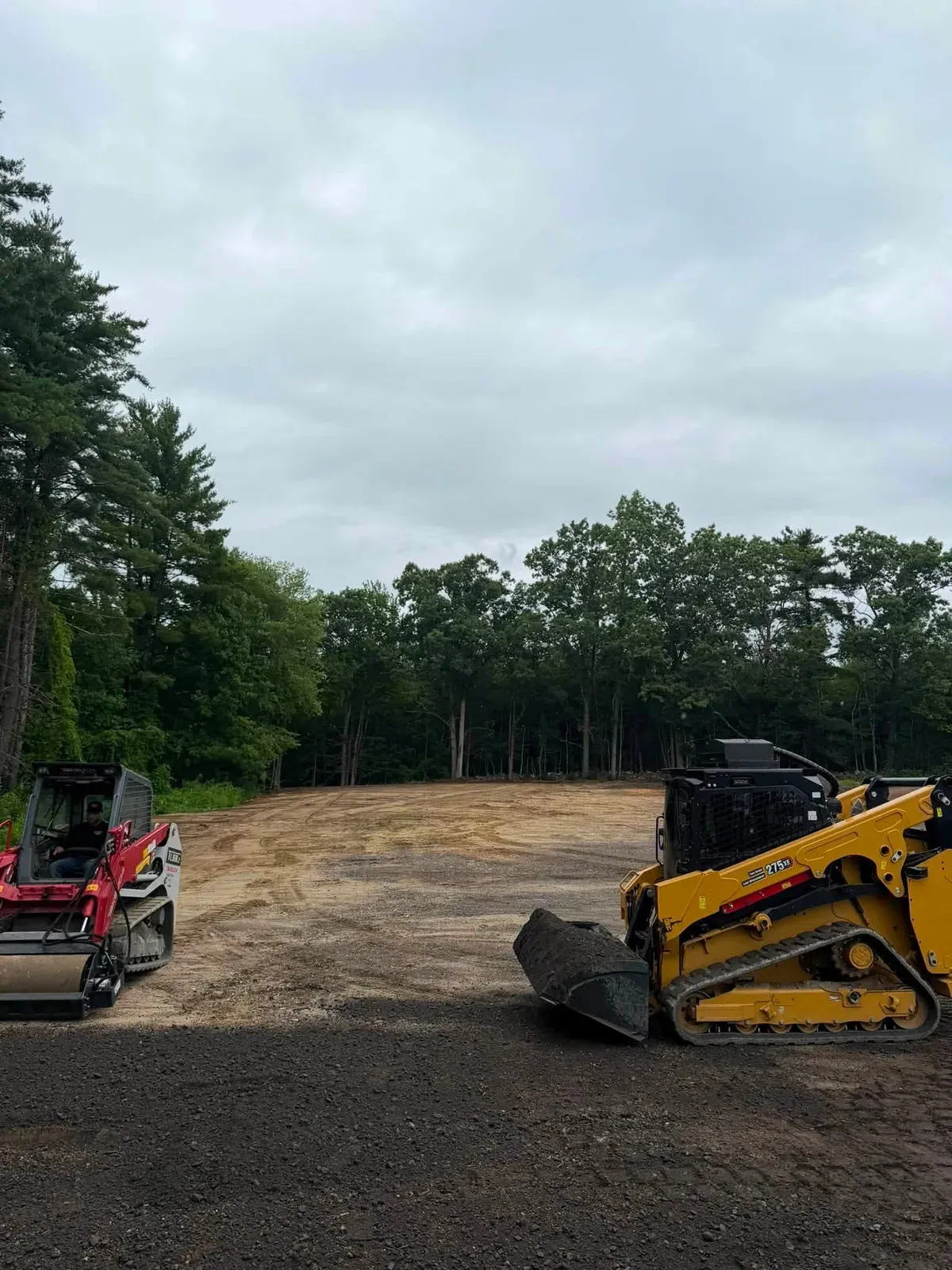 Track loaders parked on a lot after clearing a section of land