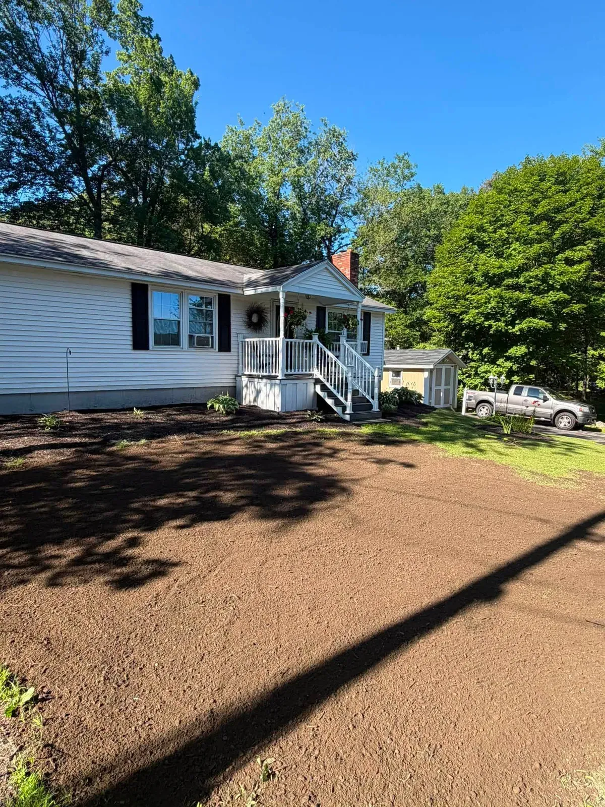 Front yard graded to bare soil in front of a ranch house